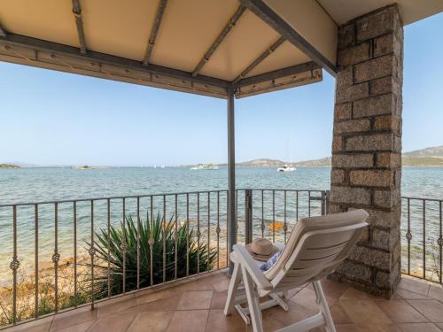 una sedia a dondolo bianca su un balcone con vista sull'oceano di Apartment Donatella by Interhome a Cannigione