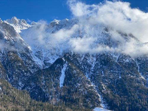a mountain covered in snow and clouds at Alpenappartements Schwalbennestl in Mittenwald