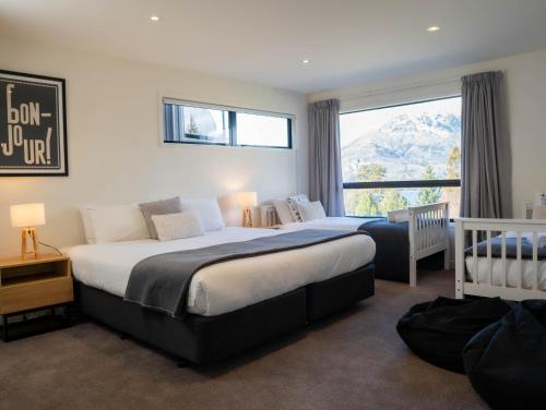 a bedroom with a large bed and a window at Wild Remarks in Queenstown