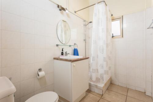 a bathroom with a toilet and a sink and a mirror at Villa Archimedes in Peyia
