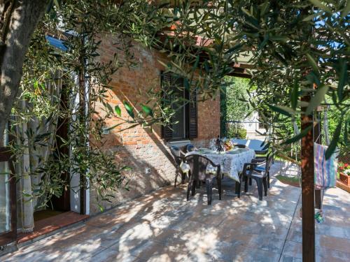 a patio with a table and chairs and trees at Holiday Home Casa Violella by Interhome in Chiusi