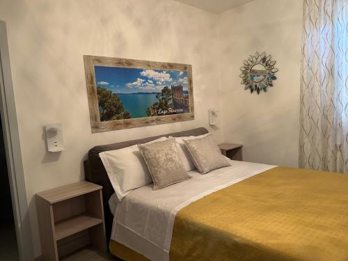 a bedroom with a bed and a painting on the wall at Dolce Dormire in Castiglione del Lago