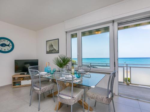 a dining room with a view of the ocean at Apartment Massimo Beach House by Interhome in Rosignano Solvay
