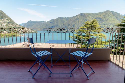 two chairs and a table on a balcony with mountains at Maraini 17 by Quokka 360 - panoramic flat near the station in Lugano