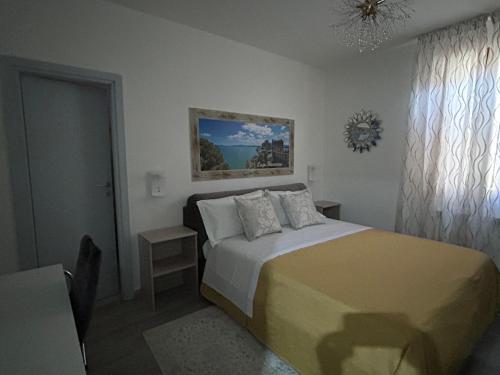 a bedroom with a bed and a painting on the wall at Dolce Dormire in Castiglione del Lago