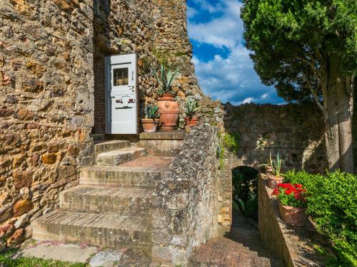 a stone wall with a door and stairs with potted plants at Apartment Torre 2 by Interhome in Stigliano