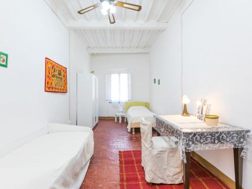 a room with two beds and a table in it at Apartment Francesco's pretty house by Interhome in Riparbella