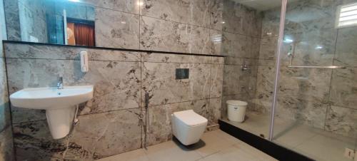 y baño con lavabo, aseo y ducha. en Sanjose Residency en Virajpet