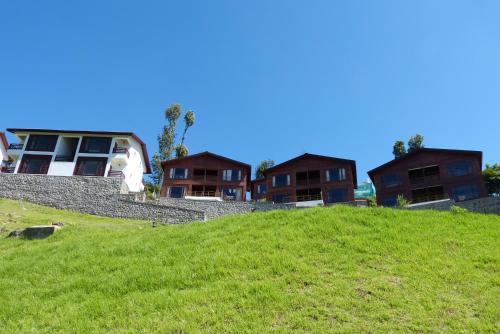 a group of houses on top of a green hill at GReaT Trails Kodaikanal by GRT Hotels in Kodaikānāl