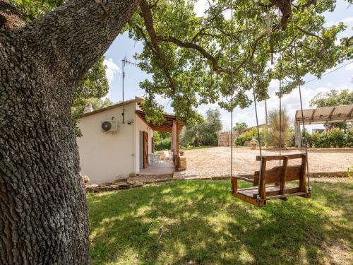 Eine Schaukel hängt von einem Baum vor einem Haus in der Unterkunft Holiday Home Casa Bianca by Interhome in Scansano