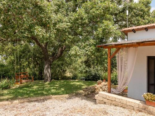 un patio con un árbol y un columpio en Holiday Home Casa Bianca by Interhome, en Scansano