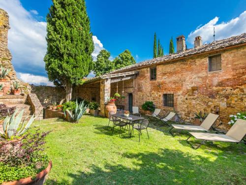 einen Garten mit einem Tisch und Stühlen sowie ein Gebäude in der Unterkunft Holiday Home La Torre by Interhome in Stigliano