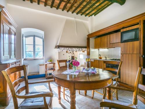 a kitchen and dining room with a wooden table and chairs at Holiday Home La Torre-4 by Interhome in Stigliano