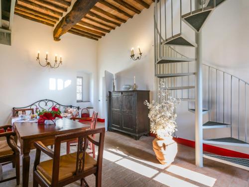 a dining room with a table and a spiral staircase at Holiday Home La Torre-4 by Interhome in Stigliano