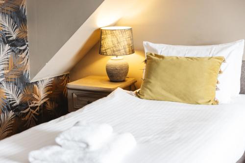 a bedroom with a bed and a lamp on a night stand at Greshornish House Hotel in Edinbane