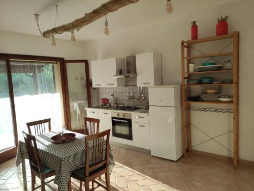 eine Küche mit einem Tisch und einem weißen Kühlschrank in der Unterkunft CASA LACONA in Lacona