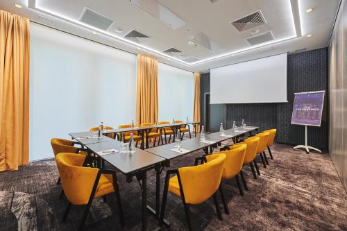 a conference room with a long table and yellow chairs at Stay inn Hotel Warszawa in Warsaw