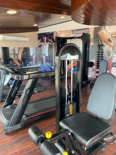 a gym with a treadmill and a simulator at Aquarios Praia Hotel in Aracaju