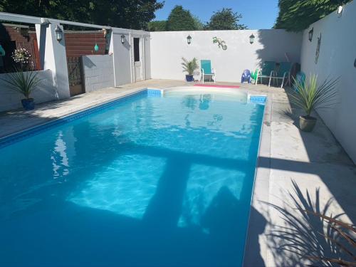 a swimming pool with blue water in a backyard at Silverspring Farm En suite in Constantine