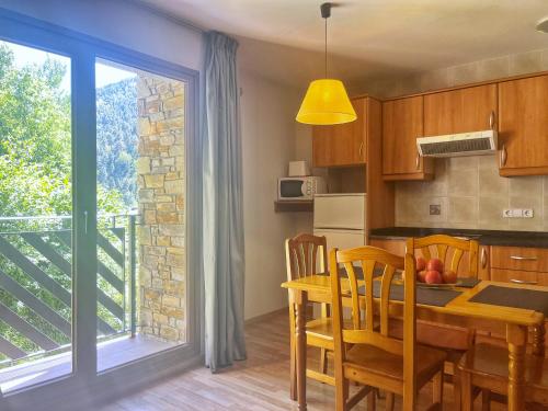 a kitchen and dining room with a table and a window at Vista Arinsal Apartments in Arinsal