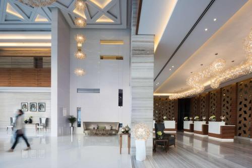 a lobby of a building with a person walking through it at Radisson Blu Hotel, Dubai Waterfront in Dubai