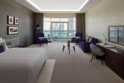 a hotel room with a bed and a living room at Radisson Blu Hotel, Dubai Waterfront in Dubai