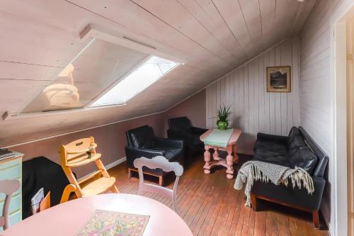 a living room with black furniture and a skylight at Tiglkåk in Åndalsnes