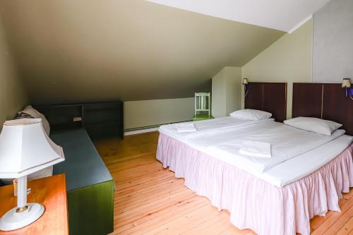 a bedroom with a large white bed and a lamp at Tiglkåk in Åndalsnes