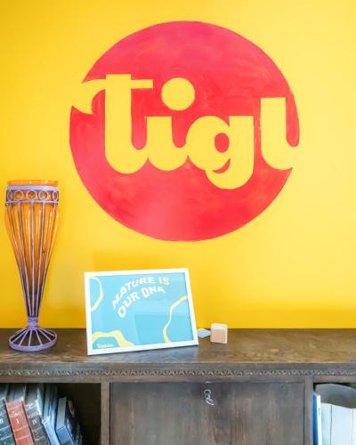 a sign on a yellow wall with a table with a book at Tiglkåk in Åndalsnes