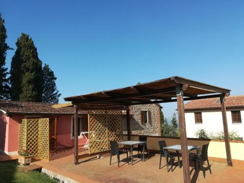 a wooden pergola with tables and chairs on a patio at Agriturismo La Forra in Cavriglia
