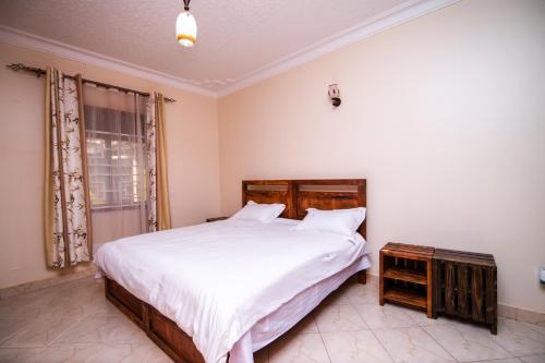 ein Schlafzimmer mit einem großen Bett und einem Fenster in der Unterkunft Tanta Guesthouse in Kira