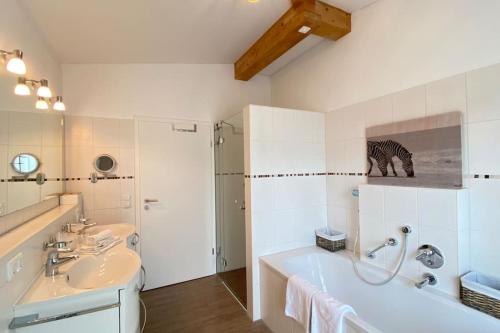 een badkamer met een bad, 2 wastafels en een zebrafoto bij Penthouse in Sonthofen in Sonthofen