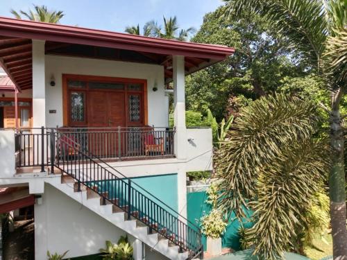 a house with a balcony and a pool at Home Stay Resort in Nilaveli