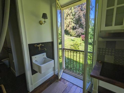 a bathroom with a sink next to a balcony at Villa Morton - Domaine du Grand Tourmalet Pic du Midi in Bagnères-de-Bigorre