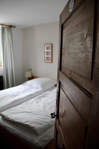 a bedroom with a bed and a wooden door at Schildwirtschaft Zum Rothen Ochsen in Laupheim