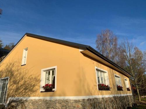 Una casa con dos ventanas con flores. en Cottage Knezice, en Petrovice