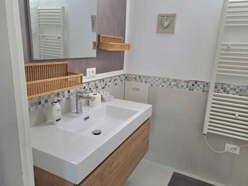 a white bathroom with a sink and a mirror at La CORTE di GIO' 1 in Nave