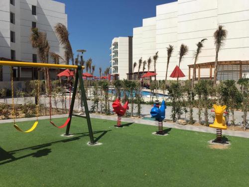 - un groupe de balançoires sur une aire de jeux dans un complexe dans l'établissement Porto Said Resort Rentals, à Port-Saïd
