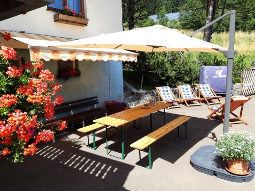 a patio with a table and chairs and an umbrella at Haus-erzberg in Vordernberg