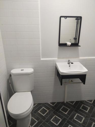 un baño con inodoro y lavabo en RoomStay Noraz, en Kampong Baharu
