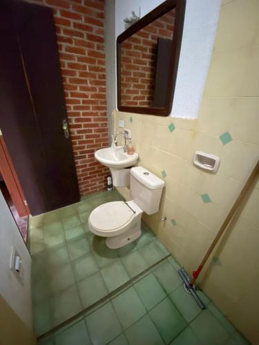 a bathroom with a toilet and a sink at Chalé em São Roque in São Roque