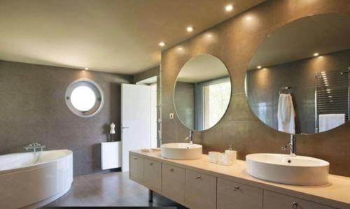 a bathroom with two sinks and two mirrors at MEDOUSA VILLA in Porto Rafti
