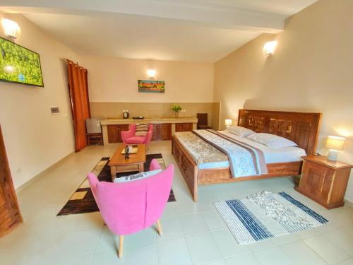 a bedroom with a bed and a table and chairs at Hôtel La Belle Etoile & SPA in Saly Portudal