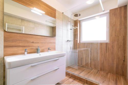 a bathroom with a white sink and a shower at Apartmany Zlatovska in Trenčín