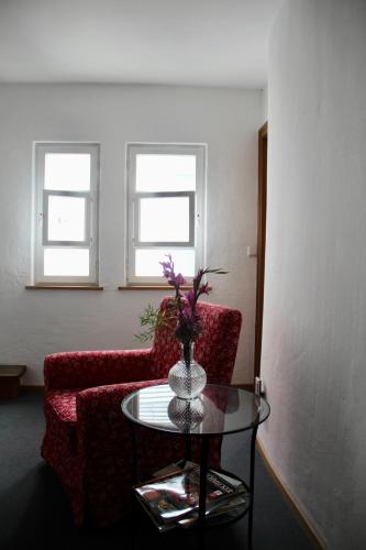 a living room with two chairs and a glass table at Schildwirtschaft Zum Rothen Ochsen in Laupheim