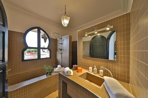 a bathroom with a sink and a mirror at DOMAINE DU DOUAR in Marrakech