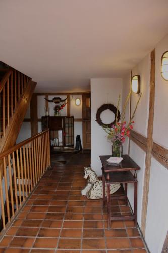 a hallway with a staircase and a table with flowers on it at Schildwirtschaft Zum Rothen Ochsen in Laupheim