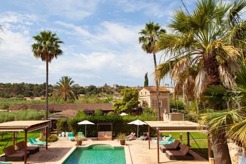 a swimming pool with palm trees and a resort at S'Hort de Son Caulelles - Adults Only in Marratxí 