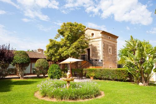 a house with a garden with a fountain in the yard at S'Hort de Son Caulelles - Adults Only in Marratxí 