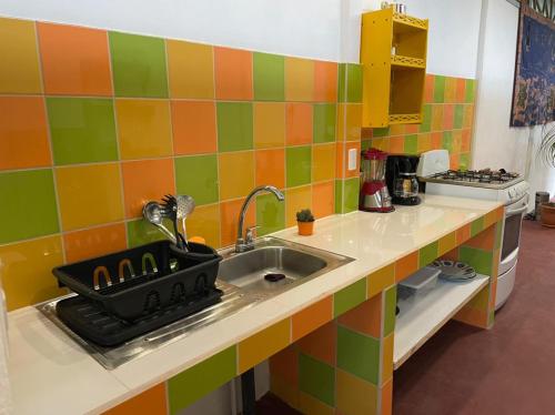 a kitchen with a sink and colorful tiles at Casita Coco in Puerto Limón